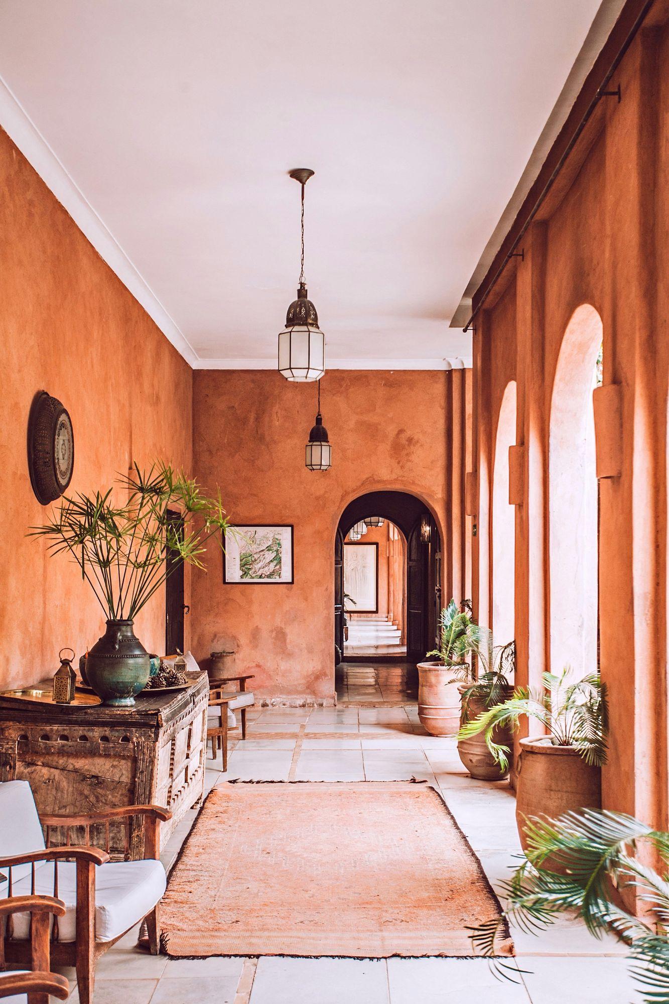A terracotta-walled riad corridor opening onto a sunlit courtyard